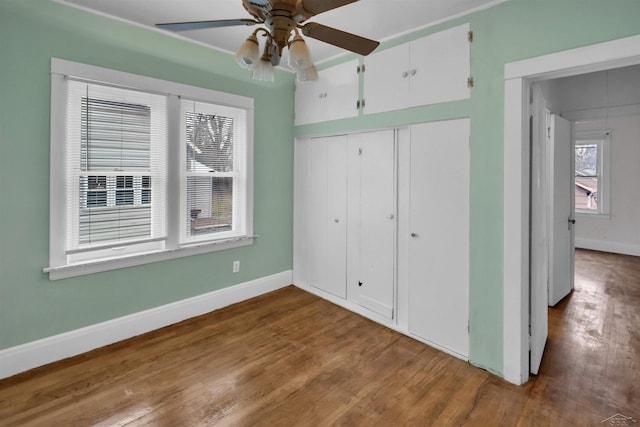 unfurnished bedroom featuring hardwood / wood-style floors, a closet, and ceiling fan