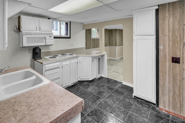 kitchen featuring a paneled ceiling, sink, white cabinets, and white appliances