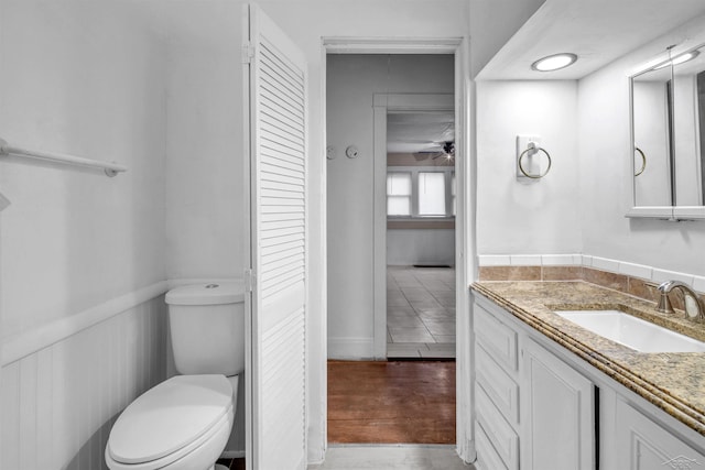 bathroom featuring ceiling fan, hardwood / wood-style floors, vanity, and toilet