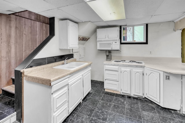 kitchen with white appliances, white cabinetry, a paneled ceiling, and sink