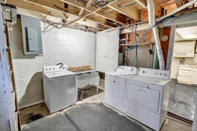 laundry area featuring sink, electric panel, and washing machine and clothes dryer