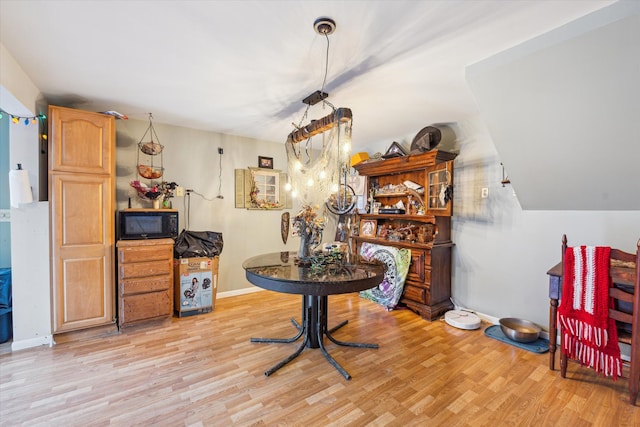 dining room featuring light hardwood / wood-style floors and vaulted ceiling