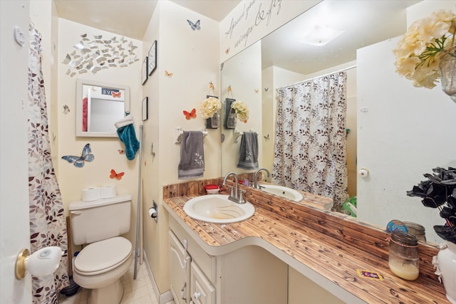 bathroom with tile patterned floors, vanity, and toilet