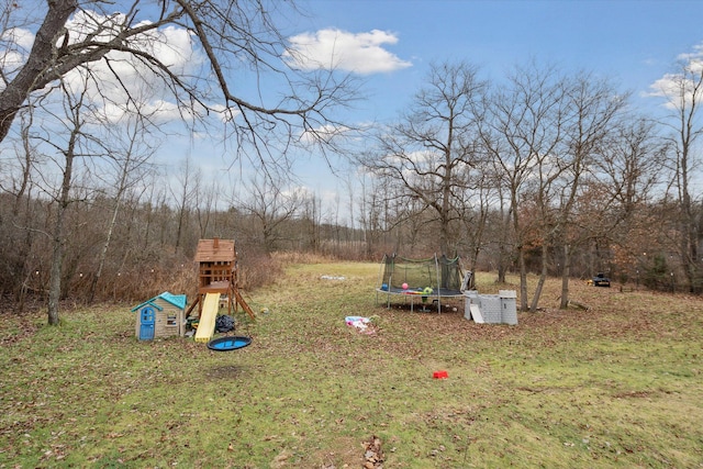 view of yard with a playground and a trampoline