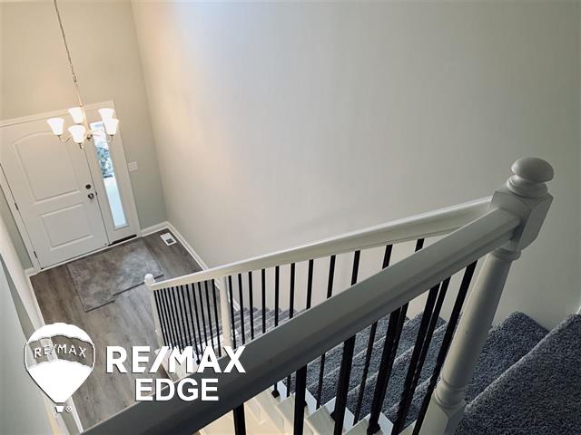 entrance foyer with hardwood / wood-style floors and a notable chandelier