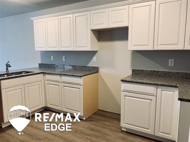 kitchen featuring dark hardwood / wood-style floors, white cabinetry, and sink