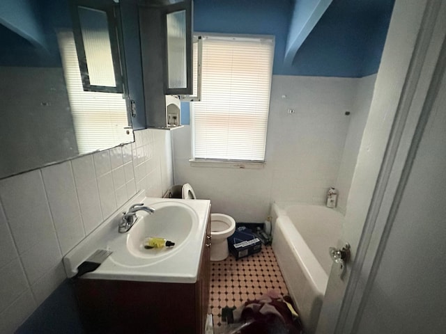 bathroom with a washtub, toilet, tile walls, and vanity