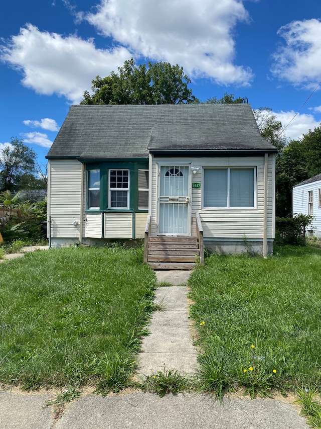 bungalow-style home with a front yard