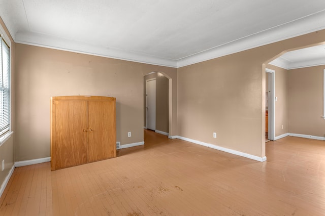 unfurnished room with light wood-type flooring and crown molding