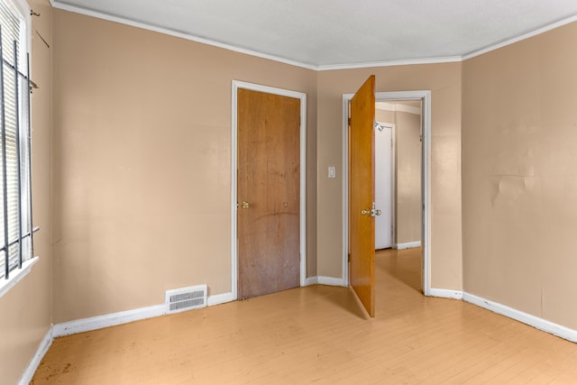 spare room with crown molding and hardwood / wood-style floors