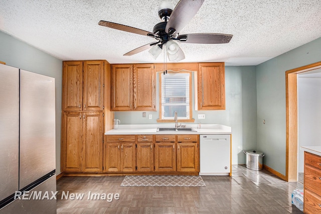 kitchen with a textured ceiling, dishwasher, stainless steel fridge, and sink