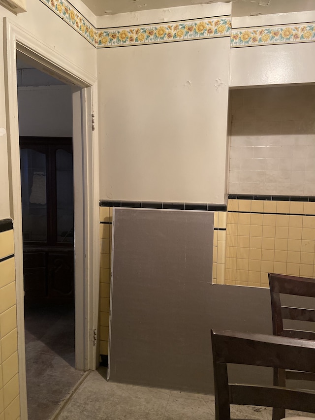 bathroom with wainscoting and tile walls