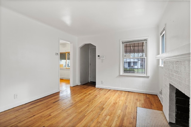 unfurnished living room with a fireplace and light wood-type flooring