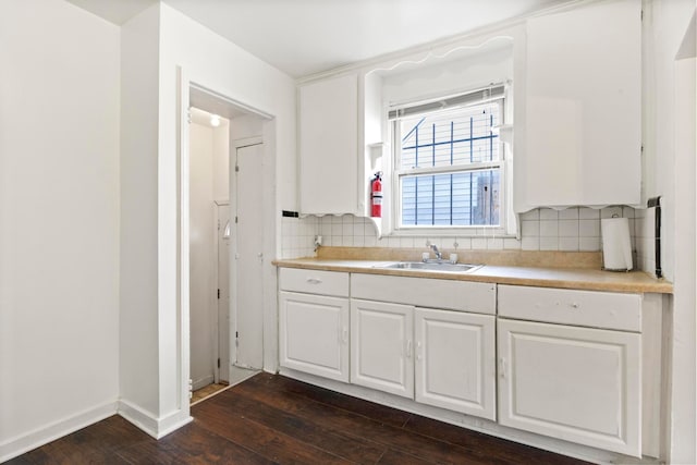 kitchen featuring backsplash, white cabinetry, sink, and dark hardwood / wood-style floors