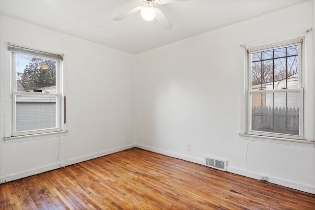 spare room featuring plenty of natural light, ceiling fan, and light wood-type flooring