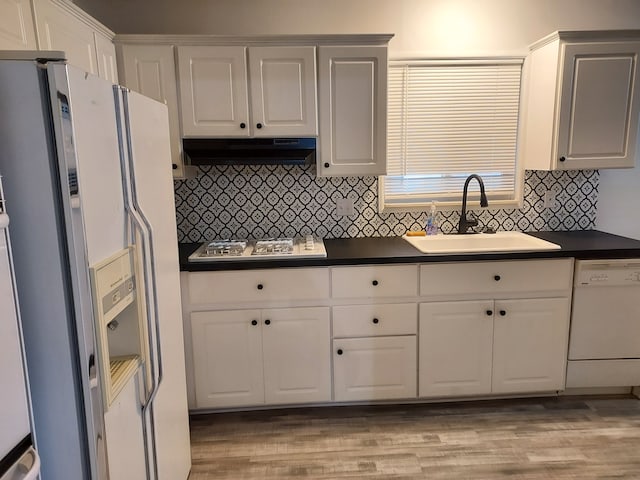 kitchen featuring decorative backsplash, light wood-type flooring, white appliances, and sink