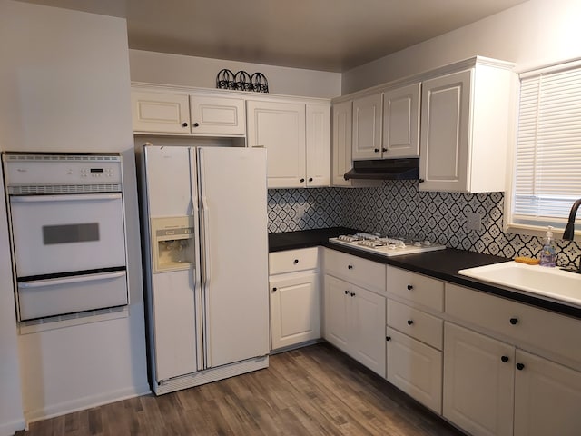 kitchen featuring decorative backsplash, white appliances, white cabinetry, and dark wood-type flooring