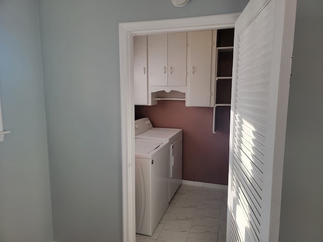 washroom featuring cabinet space, marble finish floor, independent washer and dryer, and baseboards