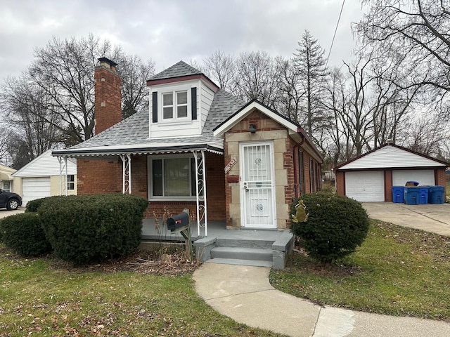 bungalow with a garage, an outdoor structure, and a front yard