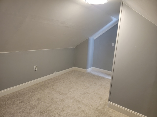 additional living space featuring vaulted ceiling, baseboards, and carpet floors