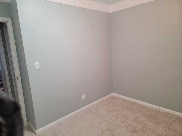 unfurnished room with light colored carpet and baseboards