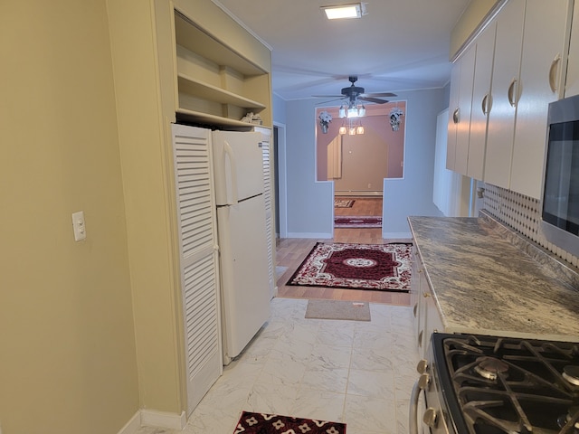 kitchen with baseboards, marble finish floor, stainless steel appliances, and ceiling fan