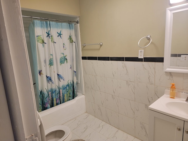 bathroom with toilet, marble finish floor, tile walls, shower / bath combination with curtain, and vanity