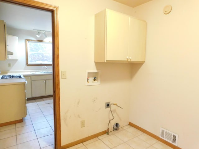 laundry area featuring sink, cabinets, washer hookup, electric dryer hookup, and light tile patterned floors