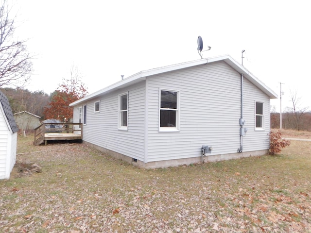 view of property exterior featuring a lawn and a wooden deck