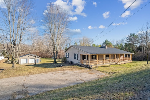 single story home with an outbuilding, a porch, a garage, and a front lawn