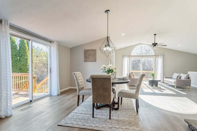 dining space featuring light hardwood / wood-style floors, vaulted ceiling, and ceiling fan