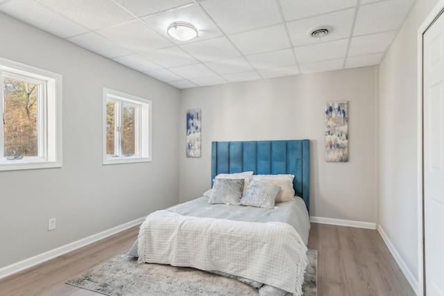 bedroom featuring a drop ceiling and light hardwood / wood-style floors