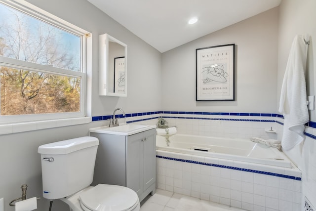 bathroom featuring vanity, a relaxing tiled tub, tile patterned flooring, toilet, and lofted ceiling