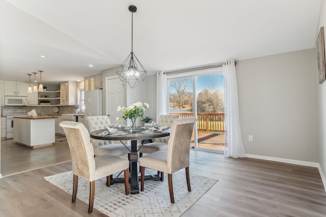 dining space with light wood-type flooring and lofted ceiling