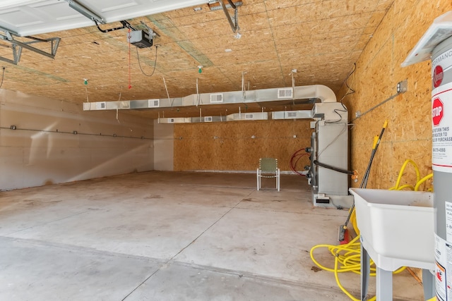 garage with sink, a garage door opener, and heating unit