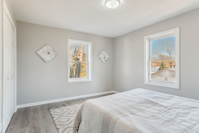 bedroom featuring a closet, light hardwood / wood-style floors, and a textured ceiling