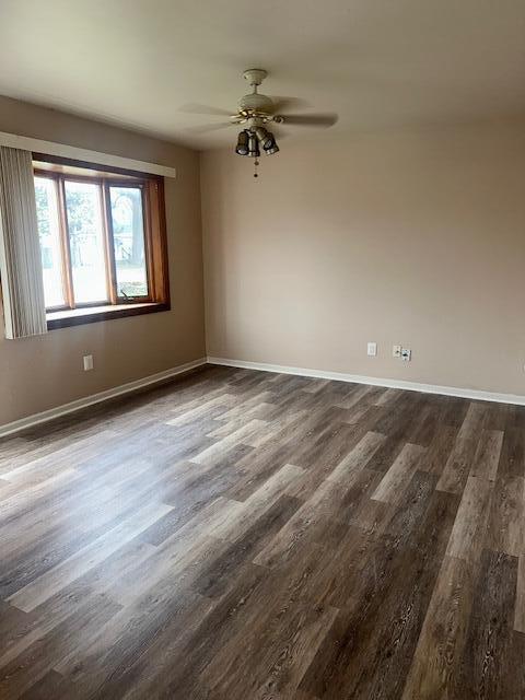 unfurnished room with ceiling fan and dark hardwood / wood-style flooring