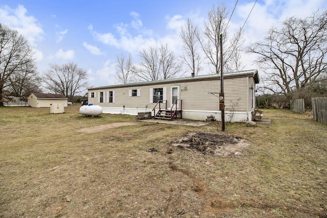 rear view of house with a lawn and an outbuilding