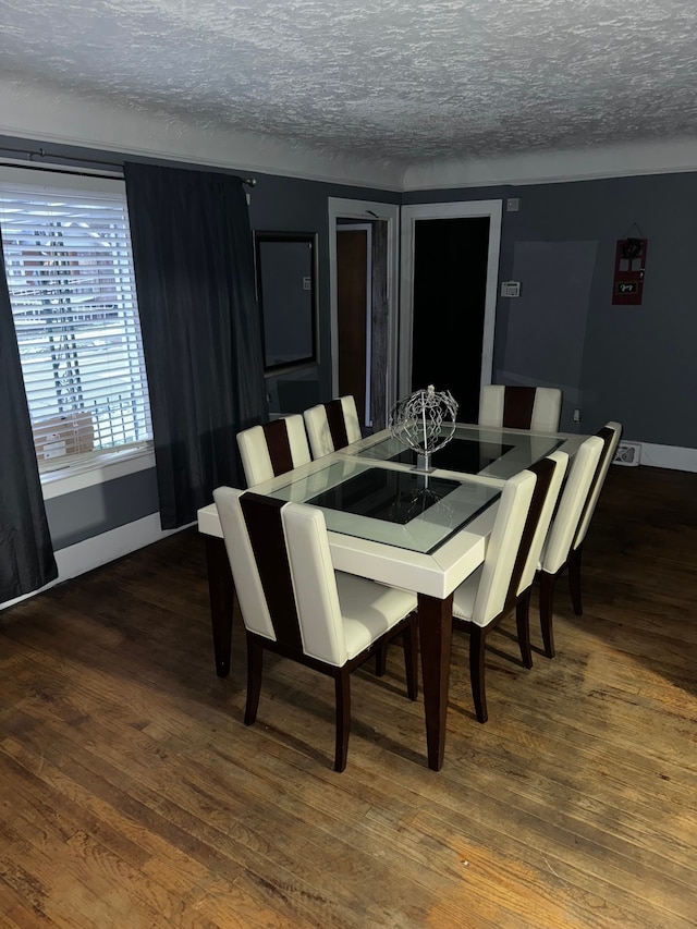 dining space featuring dark hardwood / wood-style floors and a textured ceiling