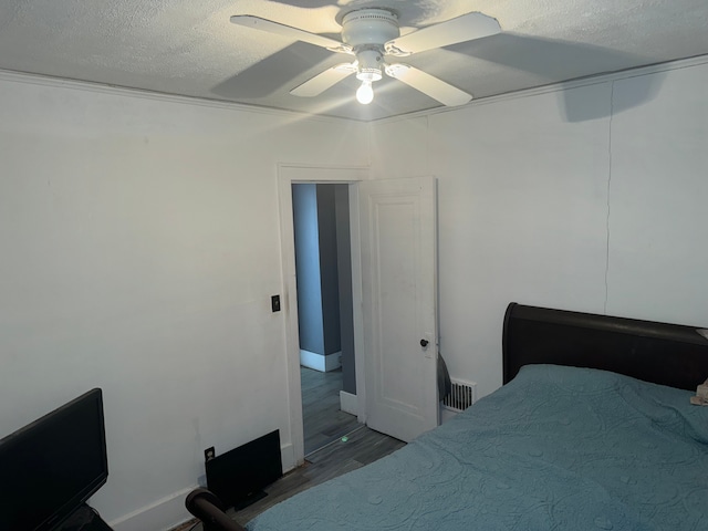 bedroom featuring ceiling fan, a textured ceiling, and hardwood / wood-style flooring