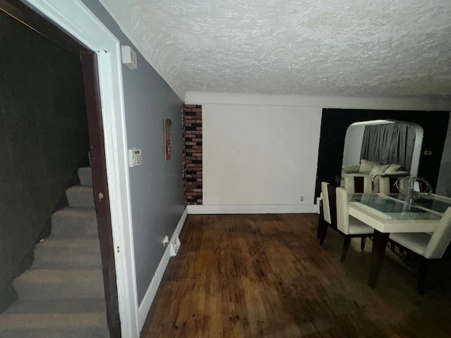 hallway with hardwood / wood-style floors and a textured ceiling