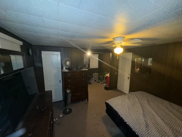 bedroom featuring ceiling fan and wooden walls