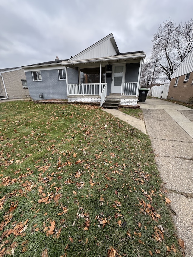 view of front of house with covered porch and a front lawn