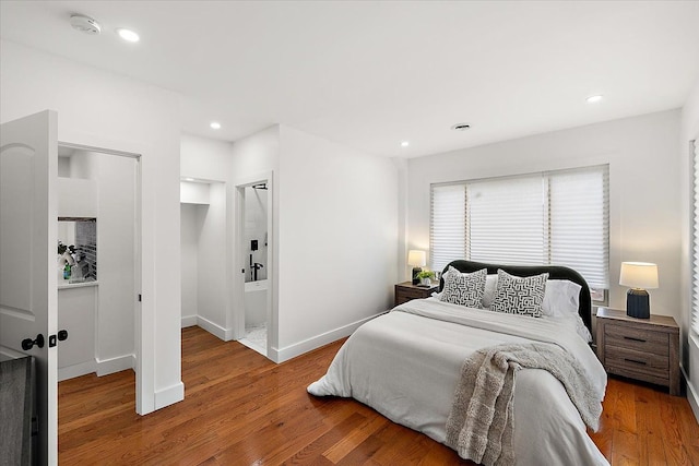 bedroom with hardwood / wood-style flooring and ensuite bathroom