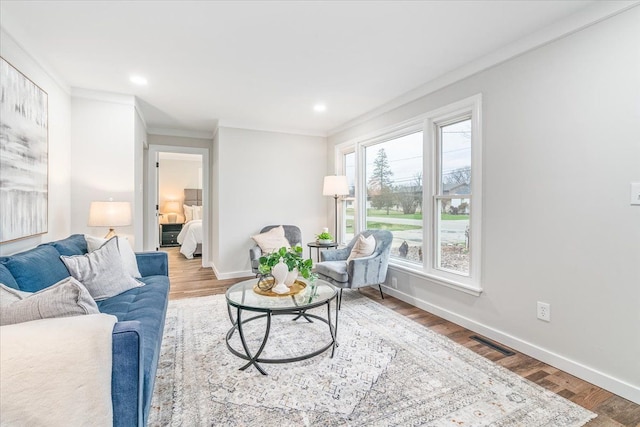 living room with crown molding and hardwood / wood-style floors