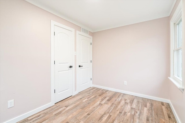 unfurnished bedroom featuring a closet and light hardwood / wood-style floors