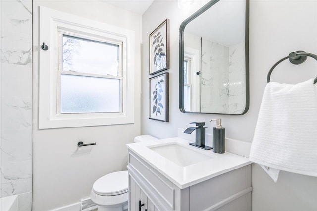 bathroom with vanity, toilet, and a healthy amount of sunlight