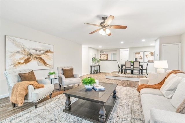 living room featuring ceiling fan and hardwood / wood-style floors