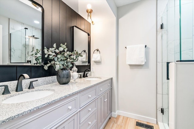 bathroom featuring hardwood / wood-style floors, vanity, and a shower with shower door