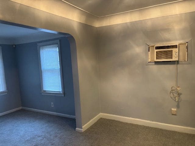 empty room with carpet flooring and a wall unit AC